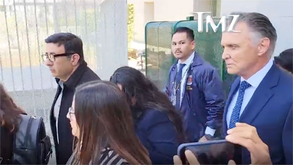 Attorney Patrick Steinfeld and his clients surrounded by media as they enter a downtown Los Angeles courthouse